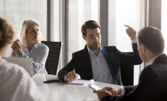 Serious,Businessmen,Businesswomen,Gathered,In,Boardroom,Discuss,New,Ideas,For
