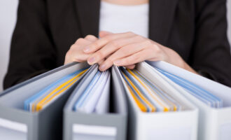 Midsection,Of,Businesswoman,With,Binders,At,Office