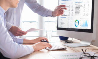 Accountants,Working,On,Financial,Statement,On,Computer,Screen,In,Office.