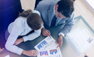 Above,View,Of,Young,Consultant,Analyzing,Data,With,Her,Client
