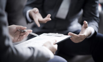 Business,Partners,Discussing,Documents,And,Ideas,At,Meeting